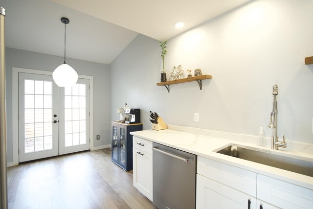 kitchen with white cabinetry, french doors, a sink, light wood finished floors, and dishwasher
