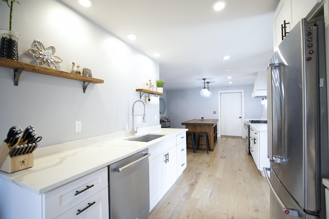 kitchen featuring a sink, open shelves, stainless steel appliances, white cabinets, and light wood-style floors