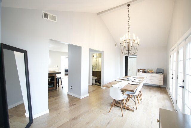 dining room featuring light wood-type flooring, a notable chandelier, beam ceiling, and visible vents