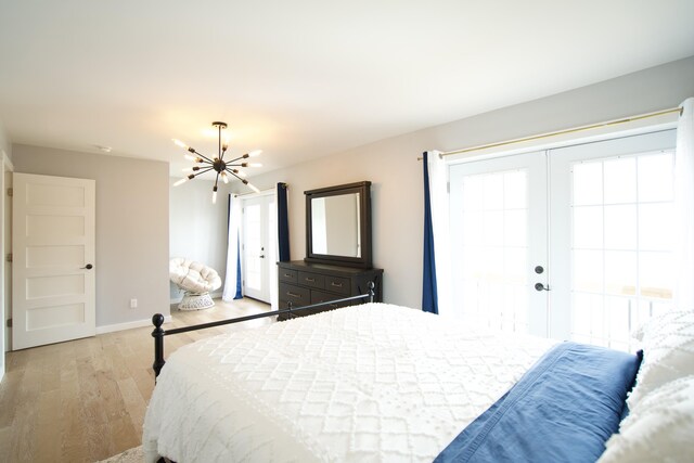 bedroom with baseboards, french doors, light wood-style floors, and a notable chandelier