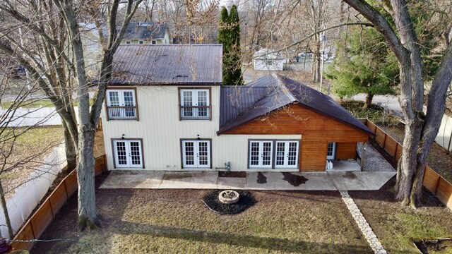 back of property featuring a fenced backyard, metal roof, a patio, and french doors