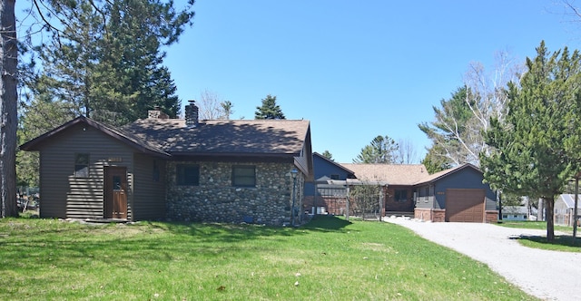 4331 N Burr Oak Rd, Lincoln, MI 48742 - single story home with a front yard, an attached garage, a chimney, gravel driveway, and stone siding