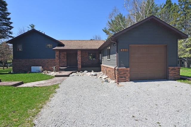 4331 N Burr Oak Rd, Lincoln, MI 48742 - single story home featuring brick siding, gravel driveway, a front yard, covered porch, and a garage