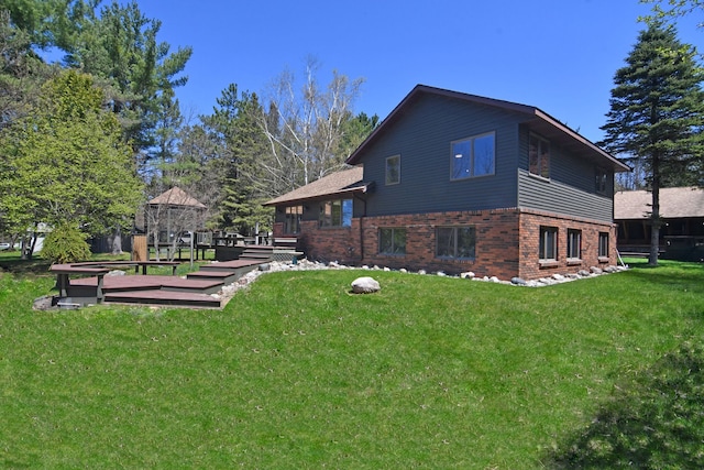 4331 N Burr Oak Rd, Lincoln, MI 48742 - rear view of house featuring brick siding, a yard, and a wooden deck
