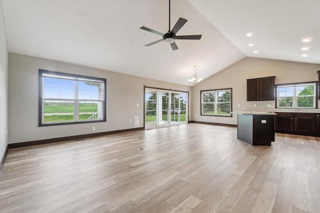 4050 Cayman Dr, Dewitt, MI 48820 - unfurnished living room with a chandelier, ceiling fan, light wood finished floors, high vaulted ceiling, and baseboards