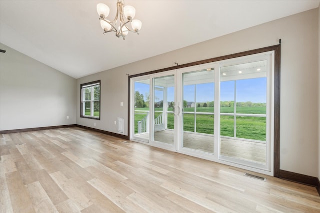 4050 Cayman Dr, Dewitt, MI 48820 - spare room featuring lofted ceiling, a chandelier, baseboards, and light wood-type flooring