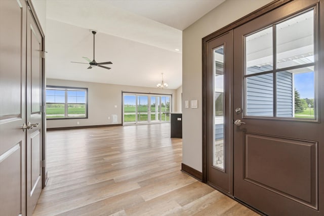 4050 Cayman Dr, Dewitt, MI 48820 - entrance foyer with ceiling fan, a chandelier, light wood-style flooring, vaulted ceiling, and baseboards