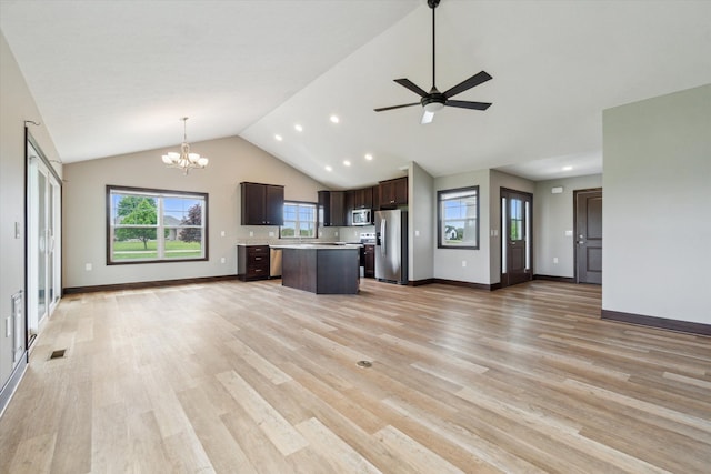 4050 Cayman Dr, Dewitt, MI 48820 - kitchen featuring appliances with stainless steel finishes, open floor plan, dark brown cabinets, vaulted ceiling, and light countertops