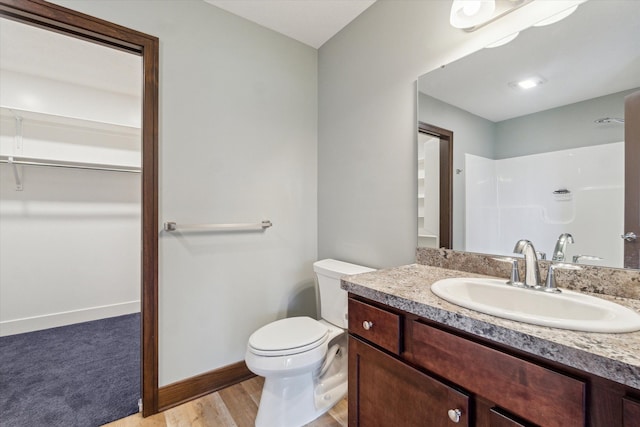 4050 Cayman Dr, Dewitt, MI 48820 - full bathroom featuring toilet, vanity, wood finished floors, and baseboards
