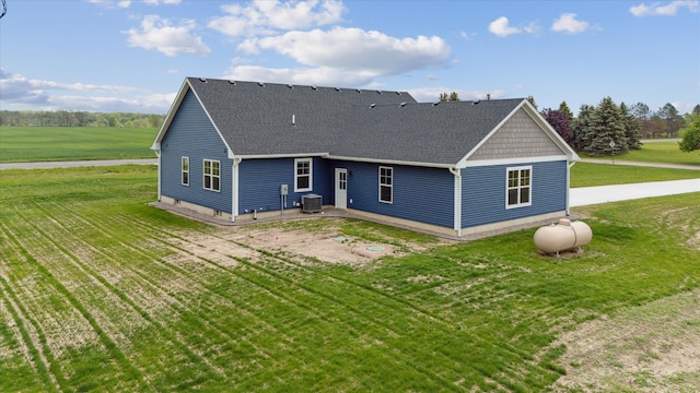 4050 Cayman Dr, Dewitt, MI 48820 - back of house with central air condition unit, a shingled roof, a yard, and a patio area