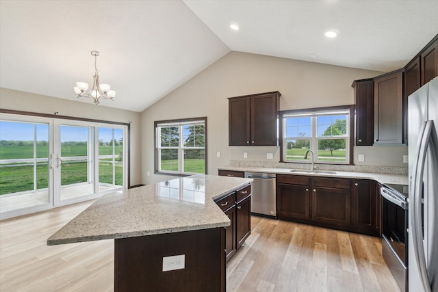 4050 Cayman Dr, Dewitt, MI 48820 - kitchen with appliances with stainless steel finishes, a sink, a kitchen island, a chandelier, and light wood-style floors