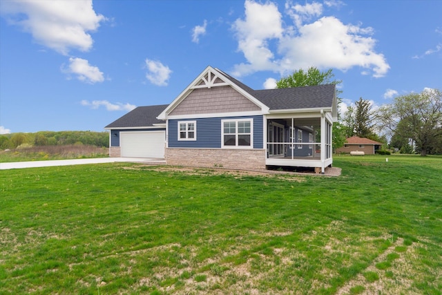 4050 Cayman Dr, Dewitt, MI 48820 - view of front of house with a sunroom, a front lawn, an attached garage, driveway, and stone siding