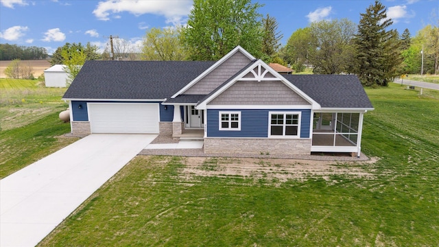 4050 Cayman Dr, Dewitt, MI 48820 - view of front of home with stone siding, an attached garage, a front lawn, concrete driveway, and roof with shingles
