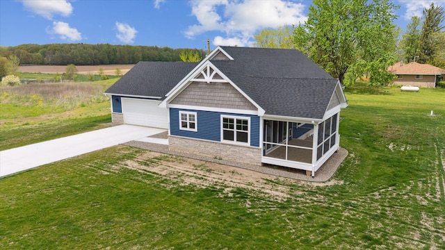 4050 Cayman Dr, Dewitt, MI 48820 - back of property featuring stone siding, driveway, a lawn, a sunroom, and roof with shingles
