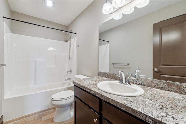 4050 Cayman Dr, Dewitt, MI 48820 - full bath featuring toilet, wood finished floors, vanity, and washtub / shower combination