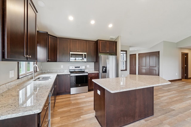 4050 Cayman Dr, Dewitt, MI 48820 - kitchen with stainless steel appliances, a sink, lofted ceiling, a center island, and dark brown cabinets