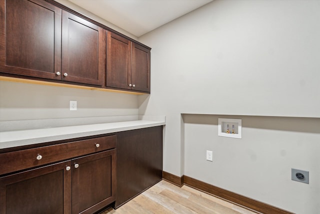 4050 Cayman Dr, Dewitt, MI 48820 - laundry area with cabinet space, hookup for an electric dryer, light wood-style flooring, washer hookup, and baseboards