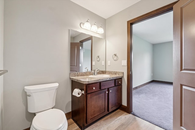 4050 Cayman Dr, Dewitt, MI 48820 - bathroom featuring toilet, vanity, wood finished floors, and baseboards