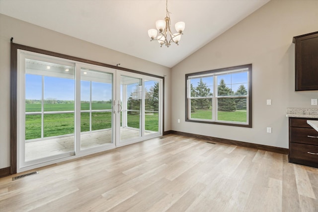 4050 Cayman Dr, Dewitt, MI 48820 - unfurnished dining area with a chandelier, light wood finished floors, baseboards, and high vaulted ceiling