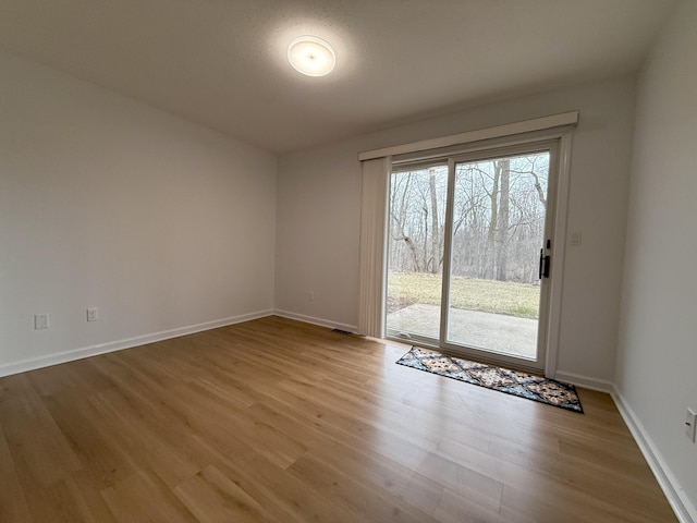 unfurnished room with baseboards and wood finished floors
