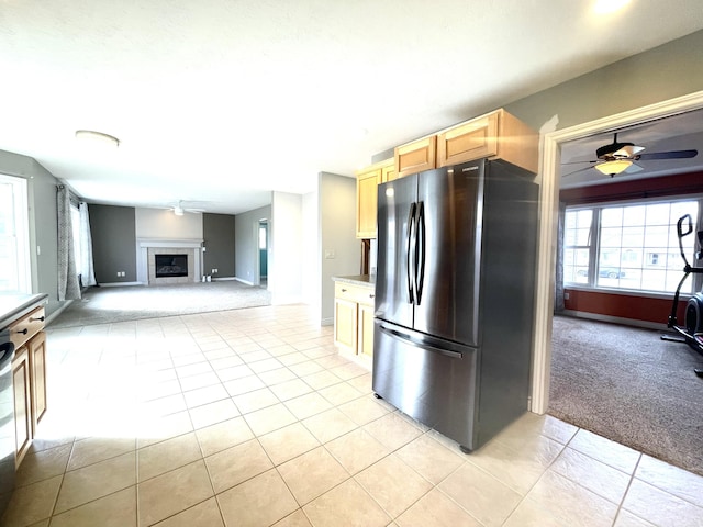 kitchen featuring freestanding refrigerator, light colored carpet, a ceiling fan, and light tile patterned floors