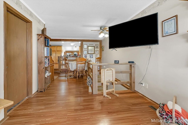 hall with light wood-style flooring, visible vents, and a textured ceiling