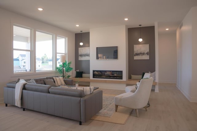 8120 Byron Depot Dr SW, Byron Center, MI 49315 - living room featuring light wood-type flooring, a glass covered fireplace, and recessed lighting