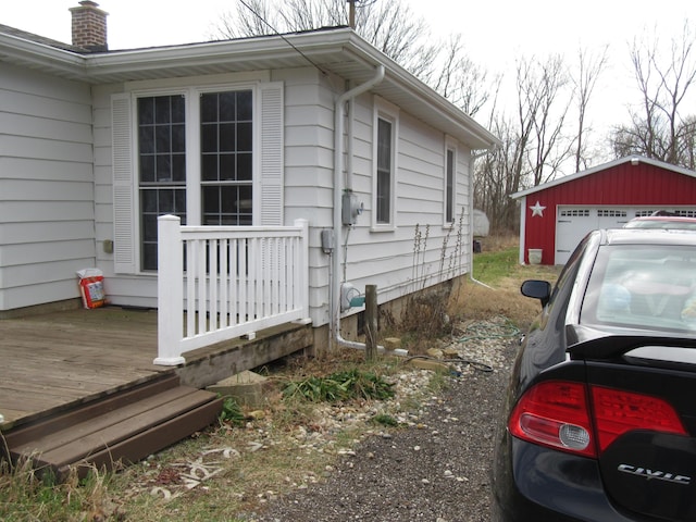 view of property exterior with an outdoor structure, a garage, and a chimney