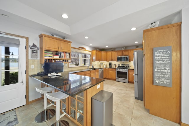 14073 Walz Blvd, Brooklyn, MI 49230 - kitchen featuring light tile patterned floors, a sink, stainless steel appliances, and a peninsula