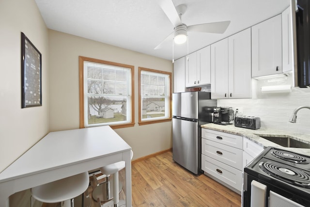 14073 Walz Blvd, Brooklyn, MI 49230 - kitchen with white cabinetry, a sink, black range with electric cooktop, and freestanding refrigerator