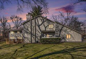 property exterior at dusk with a lawn and a chimney