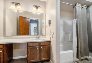 full bathroom with baseboards, vanity, and shower / bathtub combination with curtain