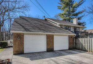 garage featuring driveway and fence