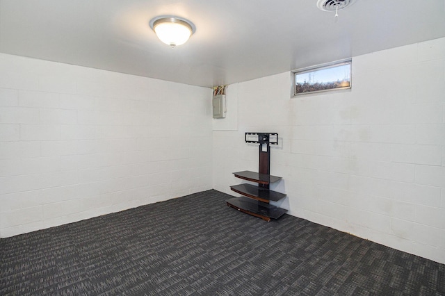 basement with electric panel, visible vents, dark colored carpet, and concrete block wall