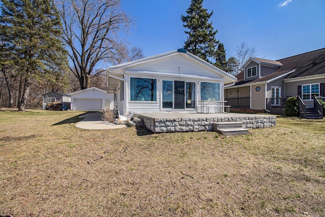 rear view of house with a wooden deck, an outbuilding, a patio, a garage, and a yard
