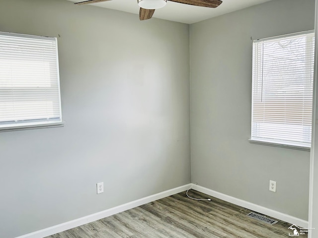 unfurnished room featuring baseboards, ceiling fan, visible vents, and wood finished floors