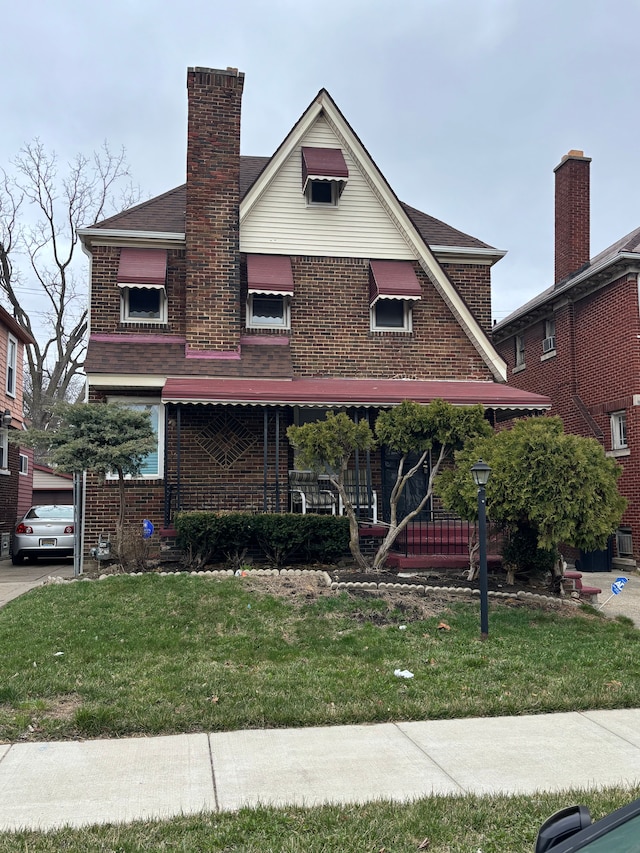 4074 Pasadena St, Detroit, MI 48238 - view of front facade with brick siding, a chimney, and a front lawn