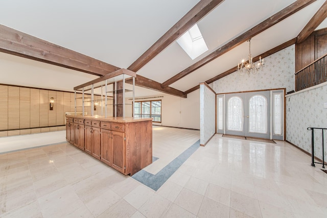 4710 Cove Rd, West Bloomfield, MI 48323 - kitchen featuring a chandelier, a skylight, open floor plan, wallpapered walls, and baseboards