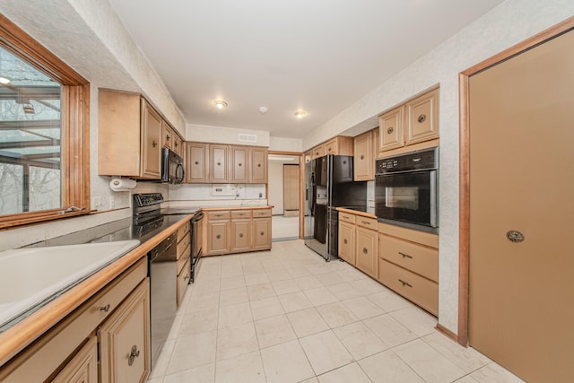 4710 Cove Rd, West Bloomfield, MI 48323 - kitchen featuring black appliances, light brown cabinets, light tile patterned floors, and light countertops