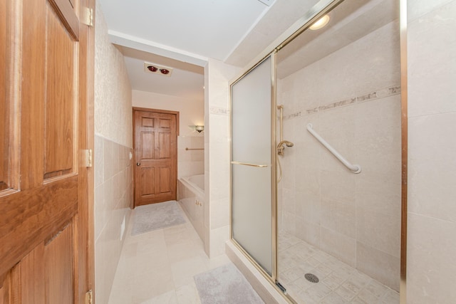 4710 Cove Rd, West Bloomfield, MI 48323 - bathroom with a shower stall, a garden tub, tile walls, and tile patterned flooring