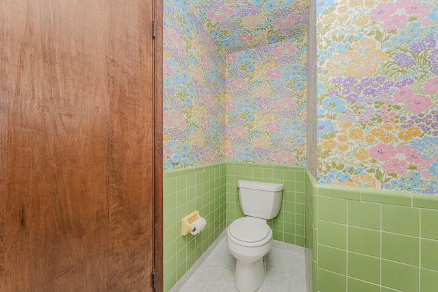 4710 Cove Rd, West Bloomfield, MI 48323 - bathroom with wallpapered walls, a wainscoted wall, toilet, tile walls, and tile patterned flooring