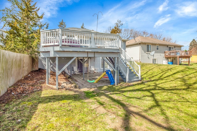 back of property with a yard, fence, a deck, and stairs