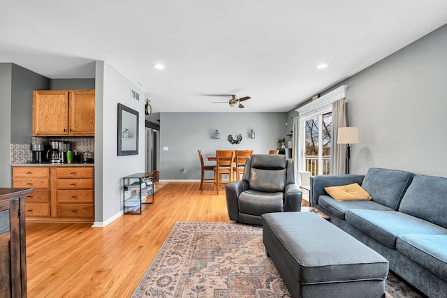 living room with recessed lighting, ceiling fan, light wood-type flooring, and baseboards