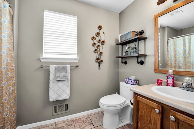 bathroom featuring toilet, vanity, baseboards, and visible vents