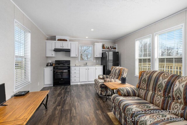 living area featuring crown molding, a textured ceiling, and dark wood finished floors