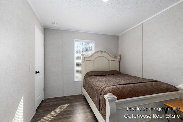 bedroom featuring a textured ceiling, wood finished floors, and crown molding