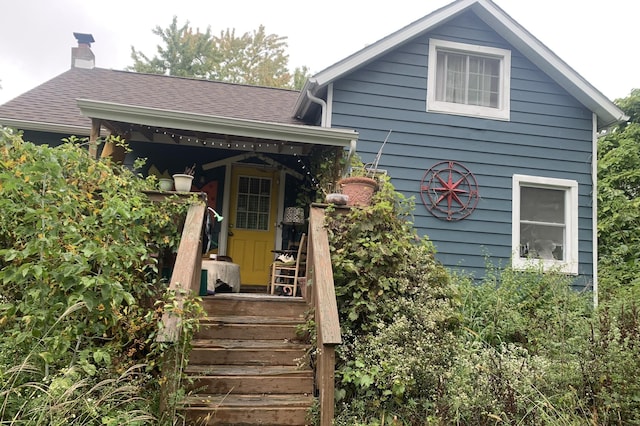 view of front of home featuring a shingled roof and a chimney