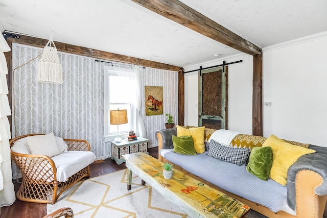 living room with a barn door, wood finished floors, beam ceiling, and ornamental molding