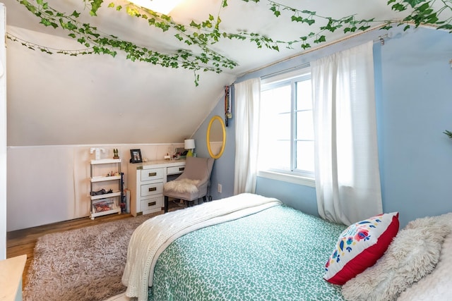 bedroom with vaulted ceiling and wood finished floors
