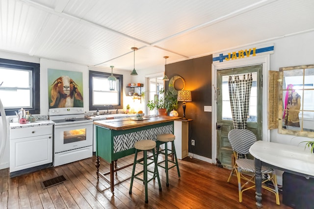 kitchen featuring dark wood-style floors, visible vents, butcher block counters, and electric range